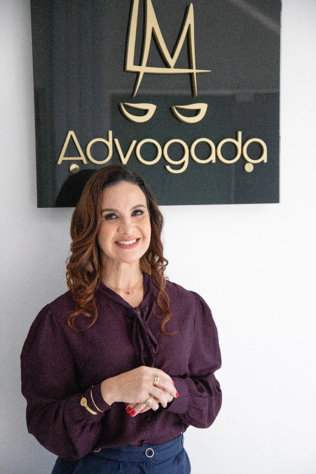 Lilian Moreno, advogada, em frente ao logotipo do escritório